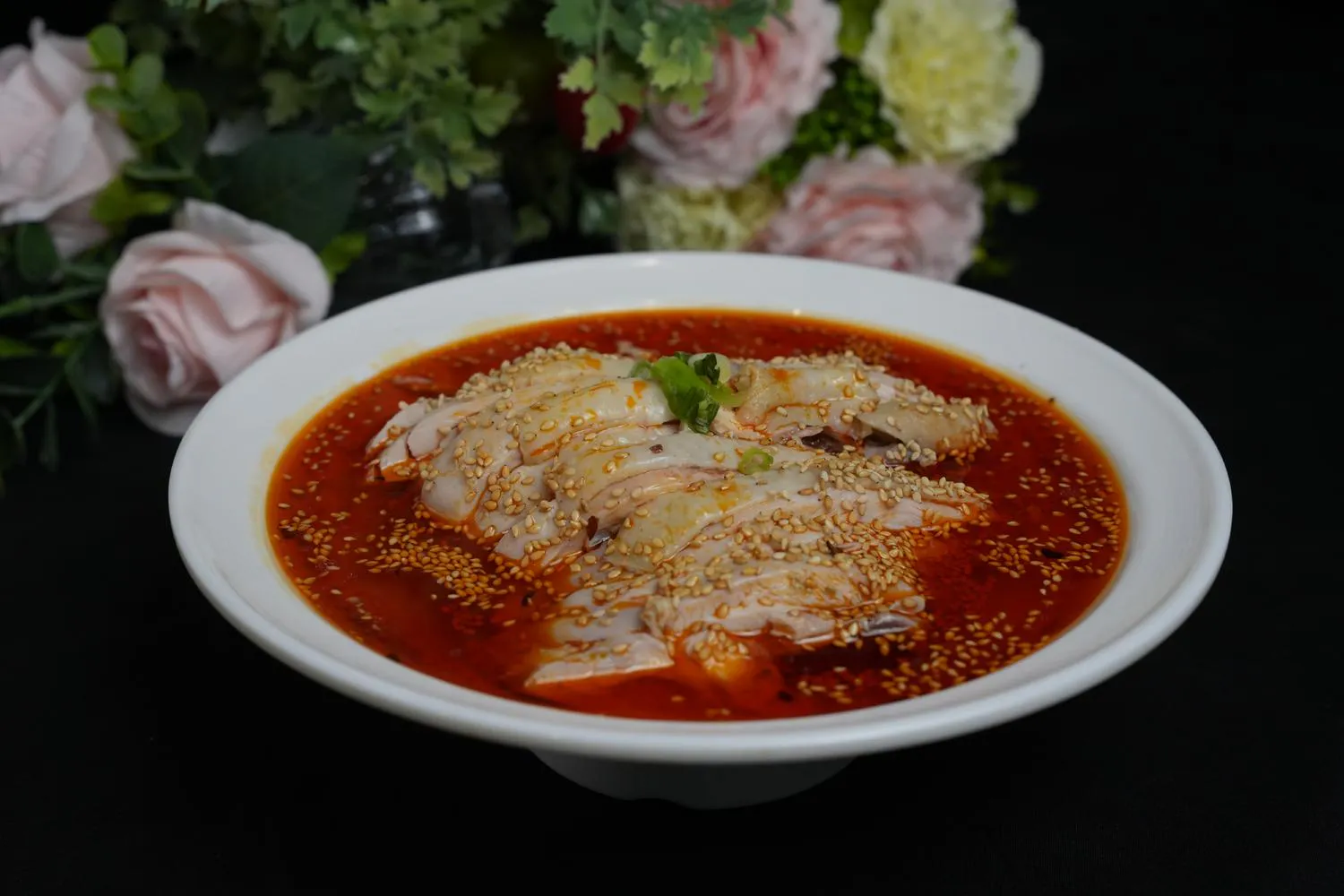 Spicy saliva chicken topped with sesame seeds in chili oil at Dumpling Party Hunan Cuisine, a Chinese Restaurant in Sugar Land
