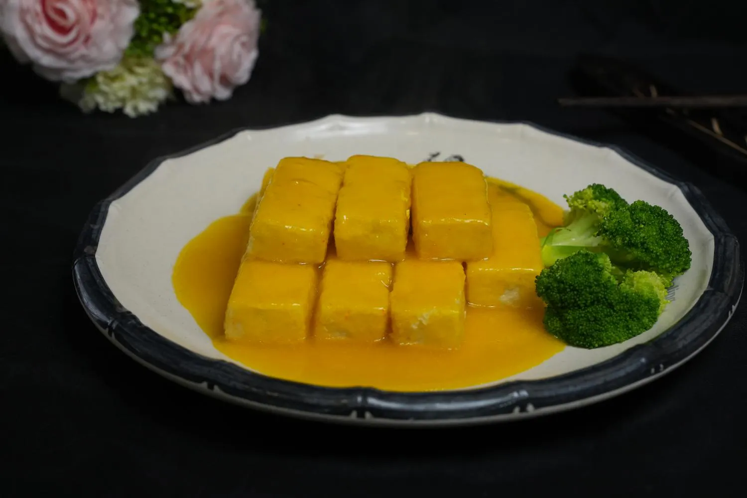 Stuffed tofu cubes soaked in golden soup with broccoli at Dumpling Party Hunan Cuisine, a Chinese Restaurant in Sugar Land