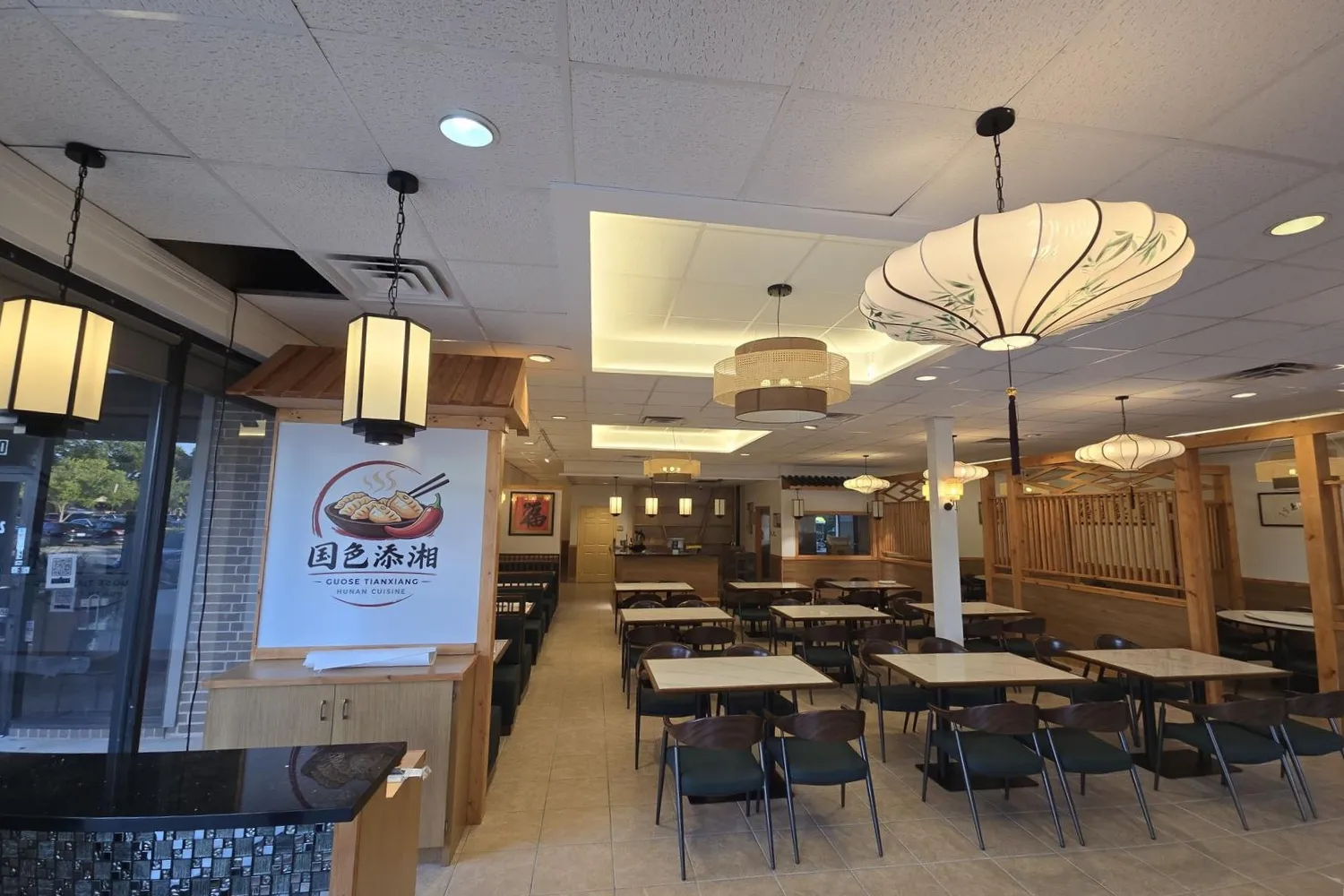 Restaurant entrance with brand wall and arranged dining tables