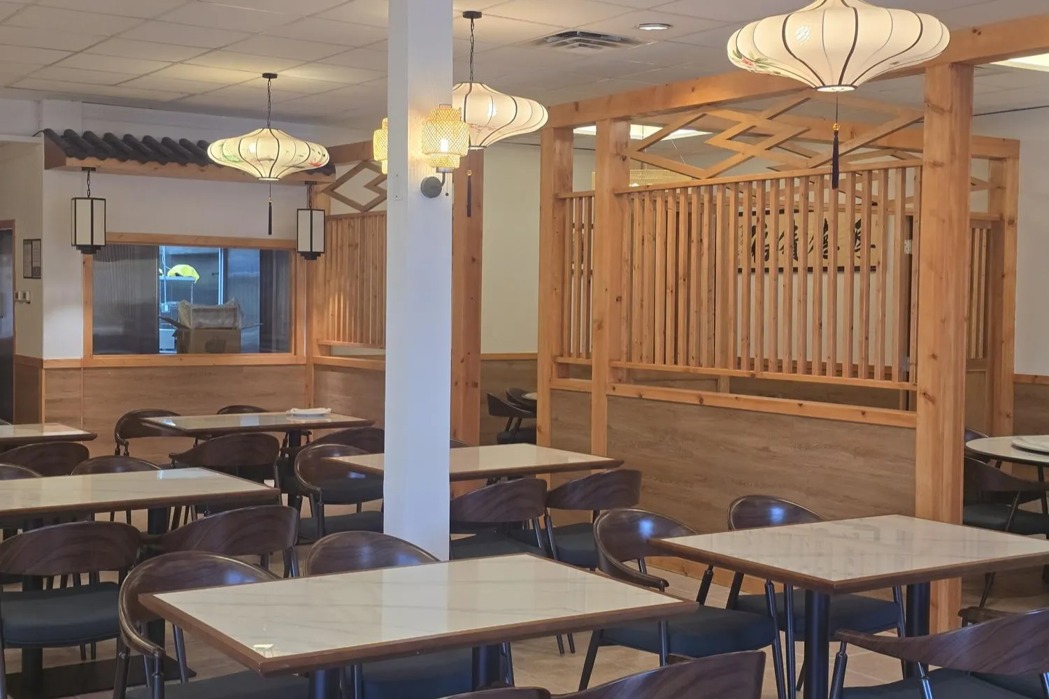 Restaurant space with pillars, wood screens and lantern lamps