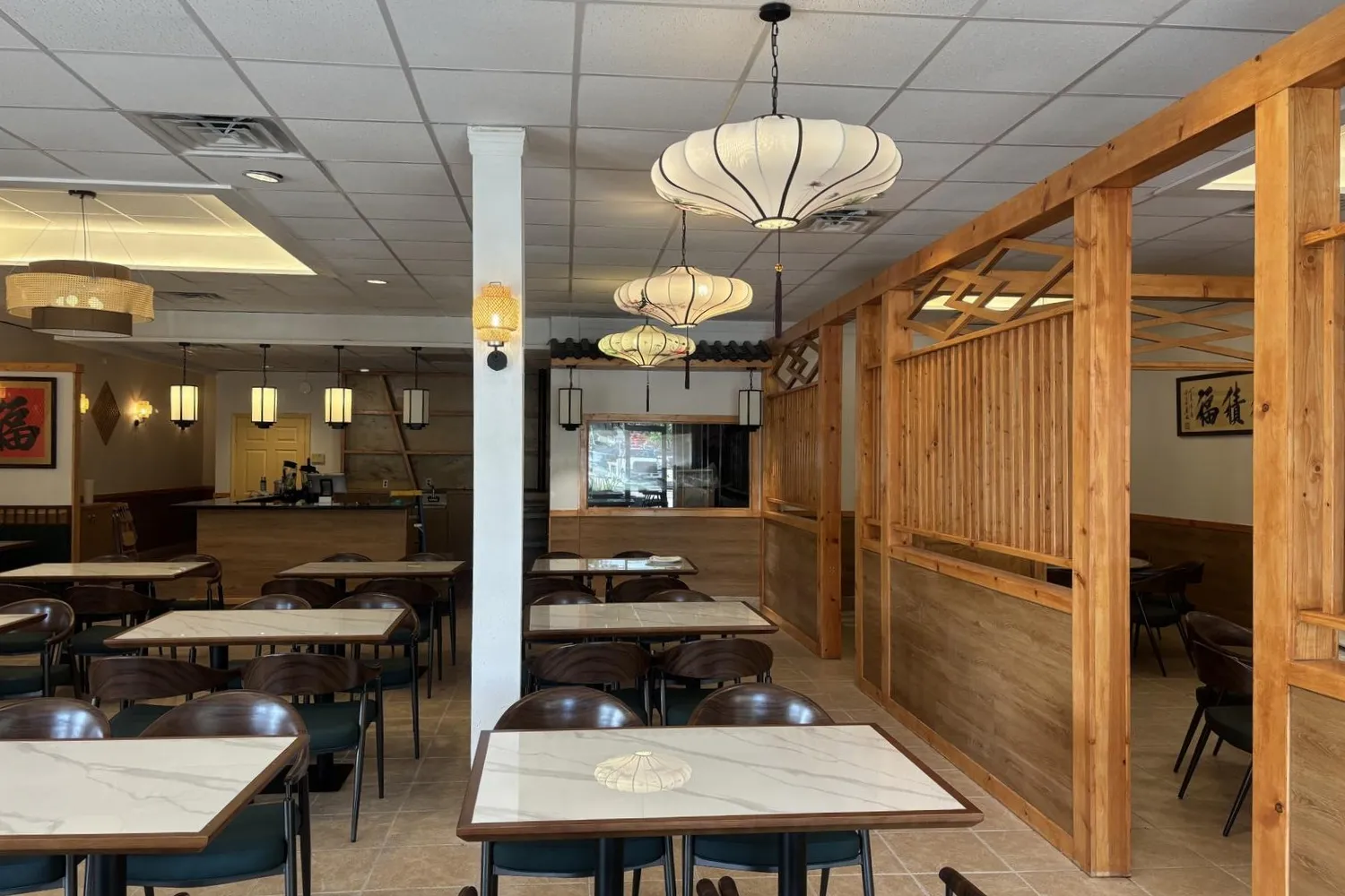 Spacious restaurant interior with wood dividers and various lanterns